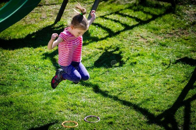 kid girl jumping green spring grass childrens park 183196103